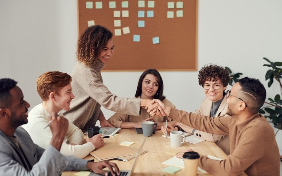 Professionals meeting and shaking hands around a table